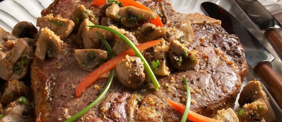 Стейк Ти-бон из американской говядины с грибами под пармезаном